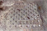 Manhole Diagonally Split Name Top R Sewer Btm L 'JORDAN' on R of Photo